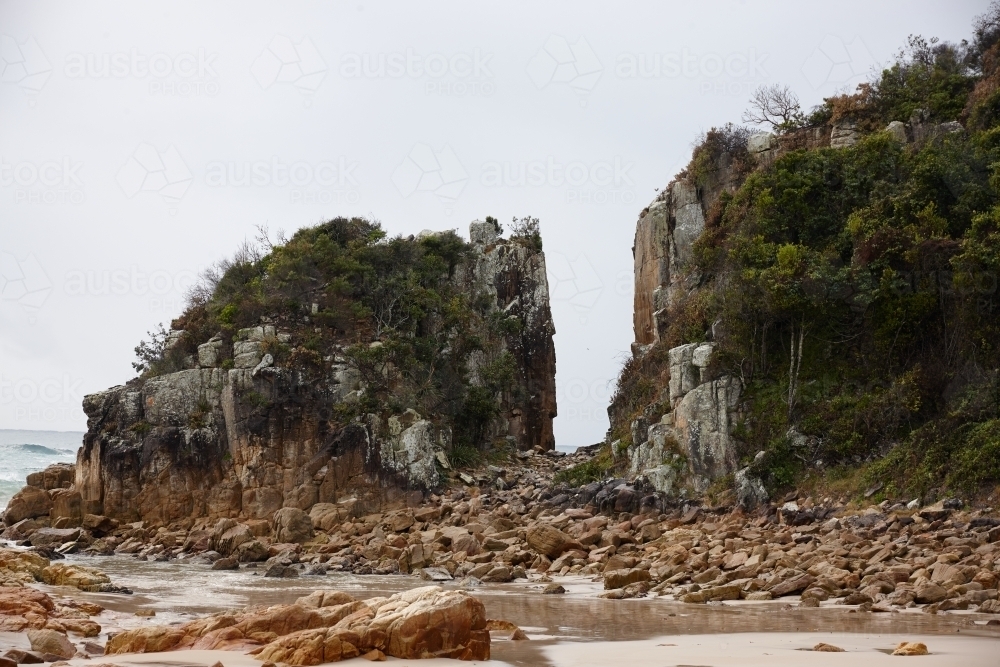 Gap in coastal rocky headland landscape on overcast morning - Australian Stock Image
