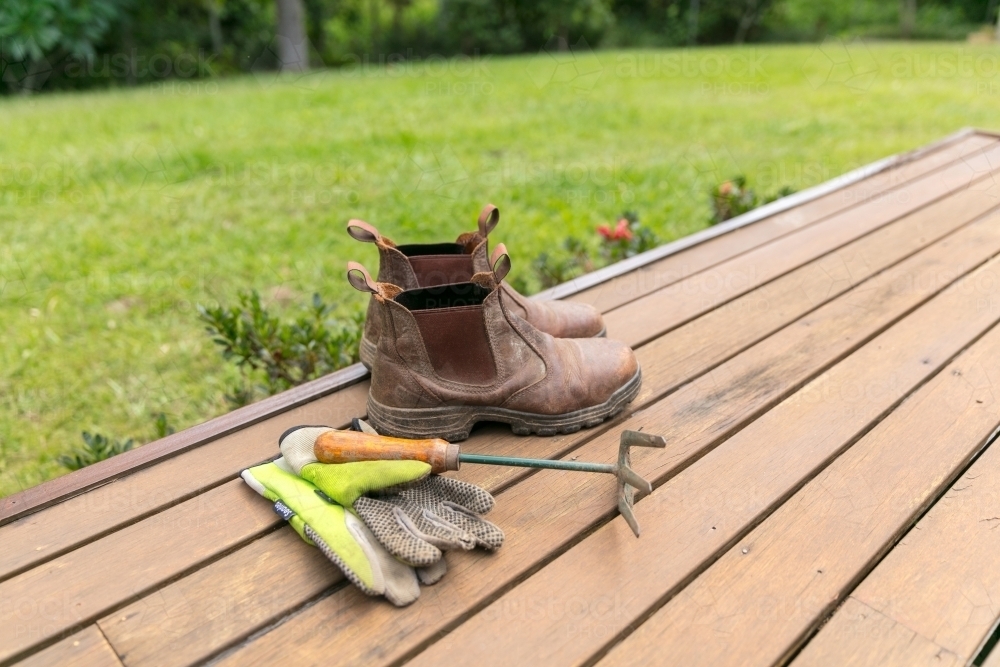 Gardening fork, gloves and boots on verandah - Australian Stock Image