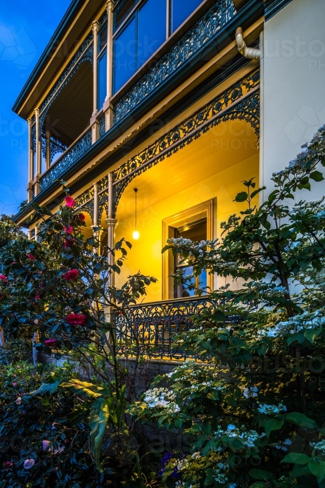 Gardens and light on front porch of the historic Corinda accommodation in Hobart at night - Australian Stock Image