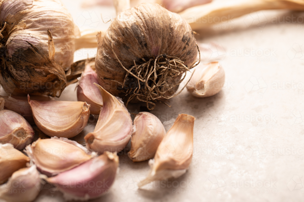 Garlic bulb and cloves on stone benchtop - Australian Stock Image