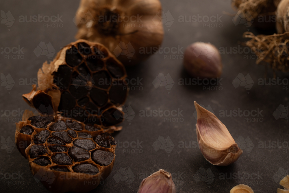Garlic bulb cut in half to show smoked cloves - Australian Stock Image