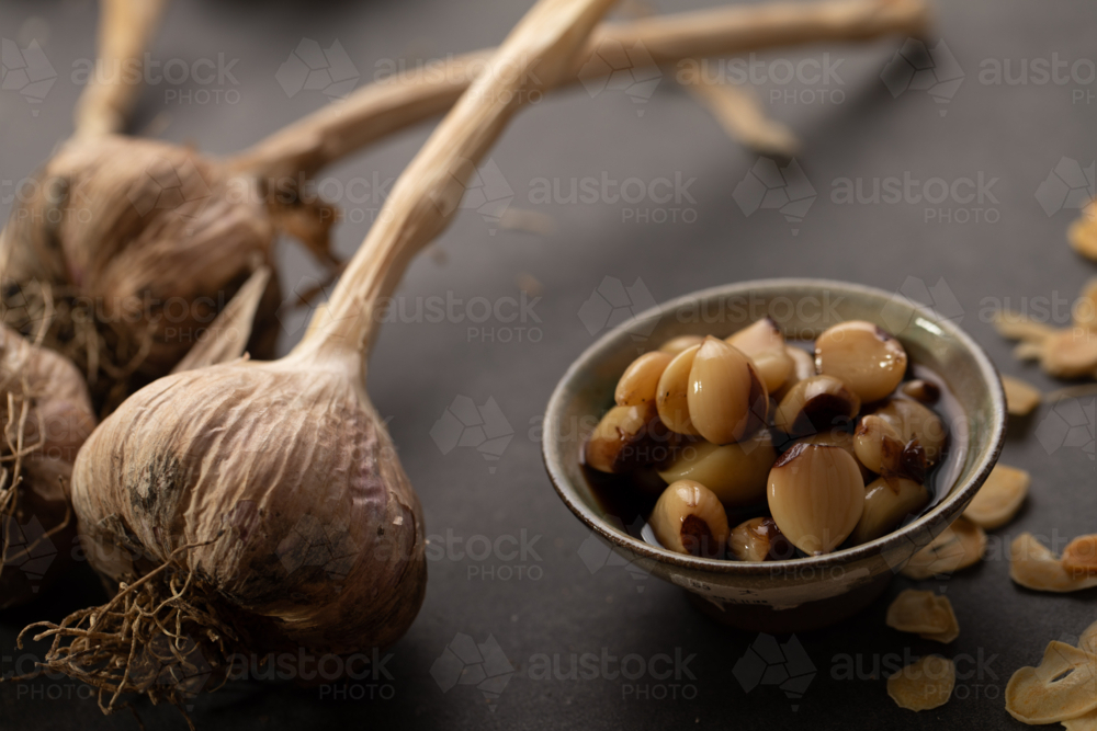 Garlic bulb with cloves on dark benchtop - Australian Stock Image
