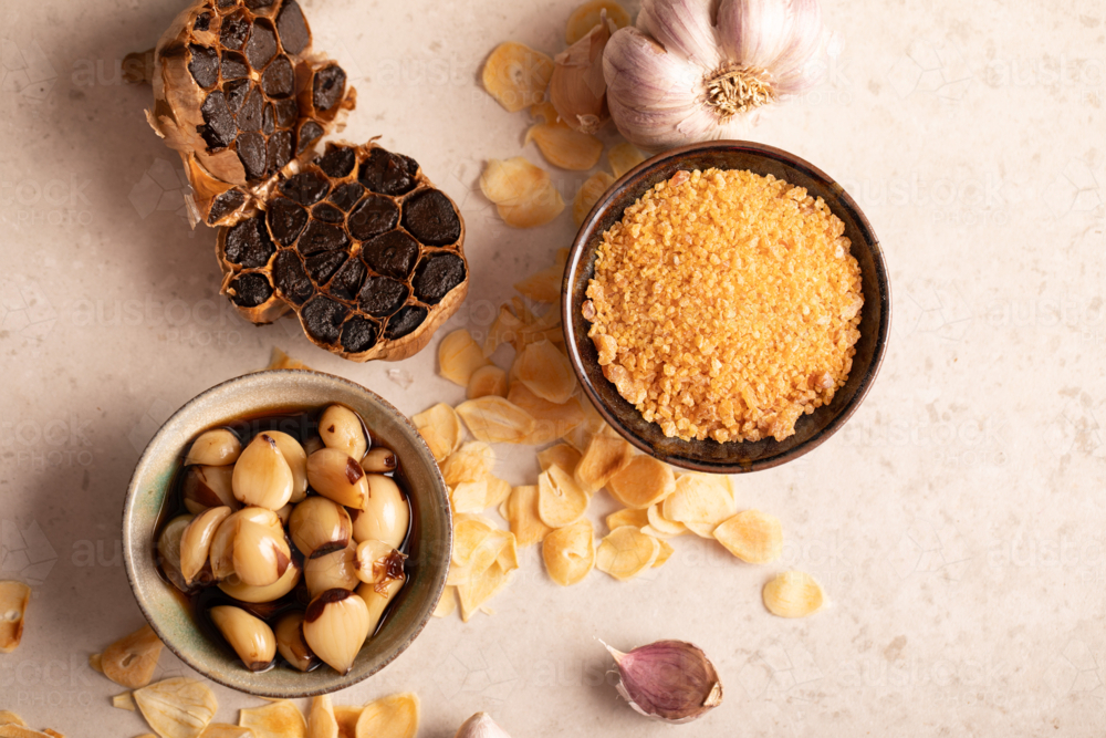 Garlic cloves and bulb and garlic salt in bowl flatlay - Australian Stock Image