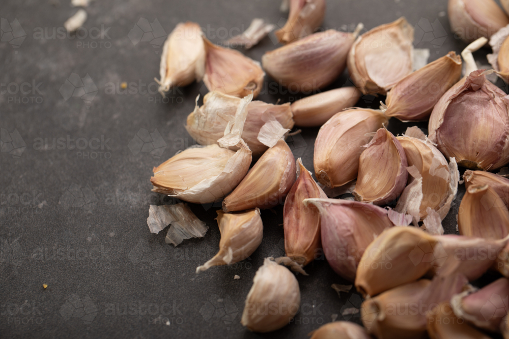 Garlic cloves on dark benchtop - Australian Stock Image