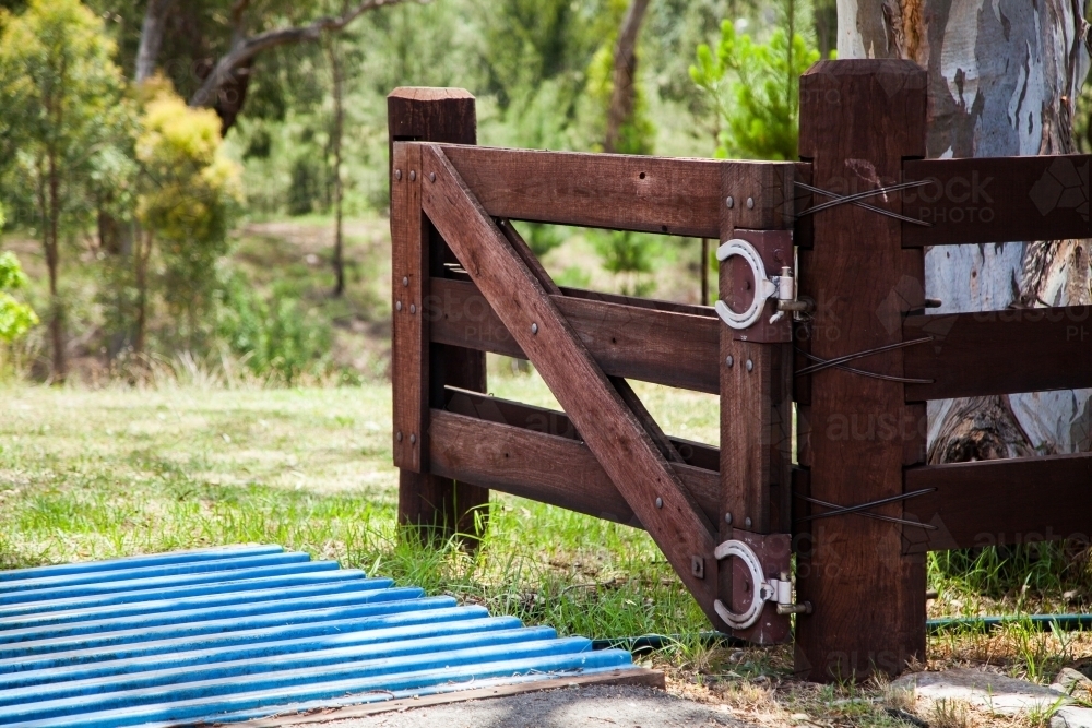 Gate and fence with cattle grid at property entrance - Australian Stock Image