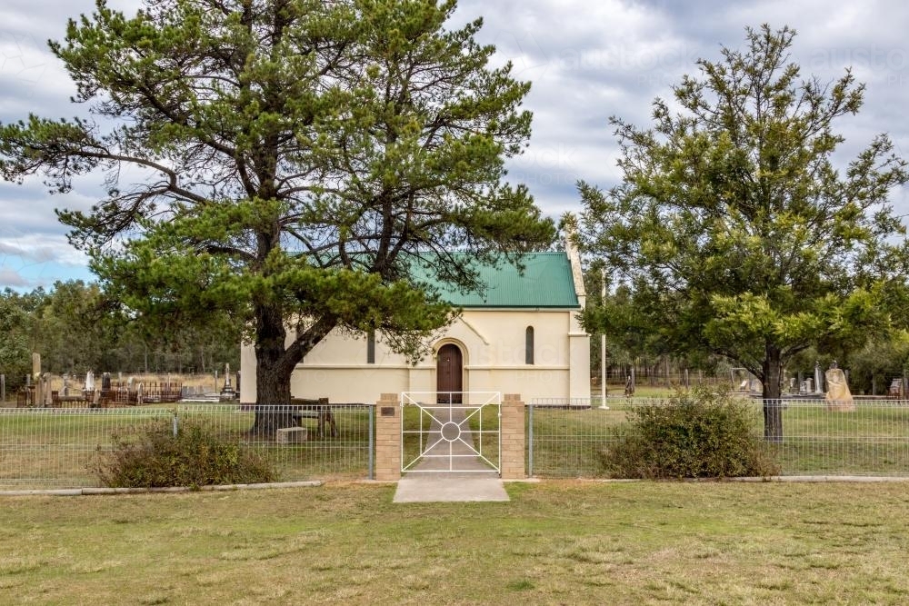 Gate and trees in front of a country church on a overcast day - Australian Stock Image