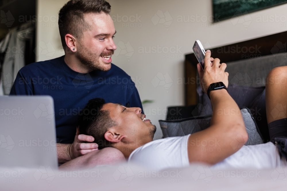 gay couple hanging out at home in the bedroom - Australian Stock Image