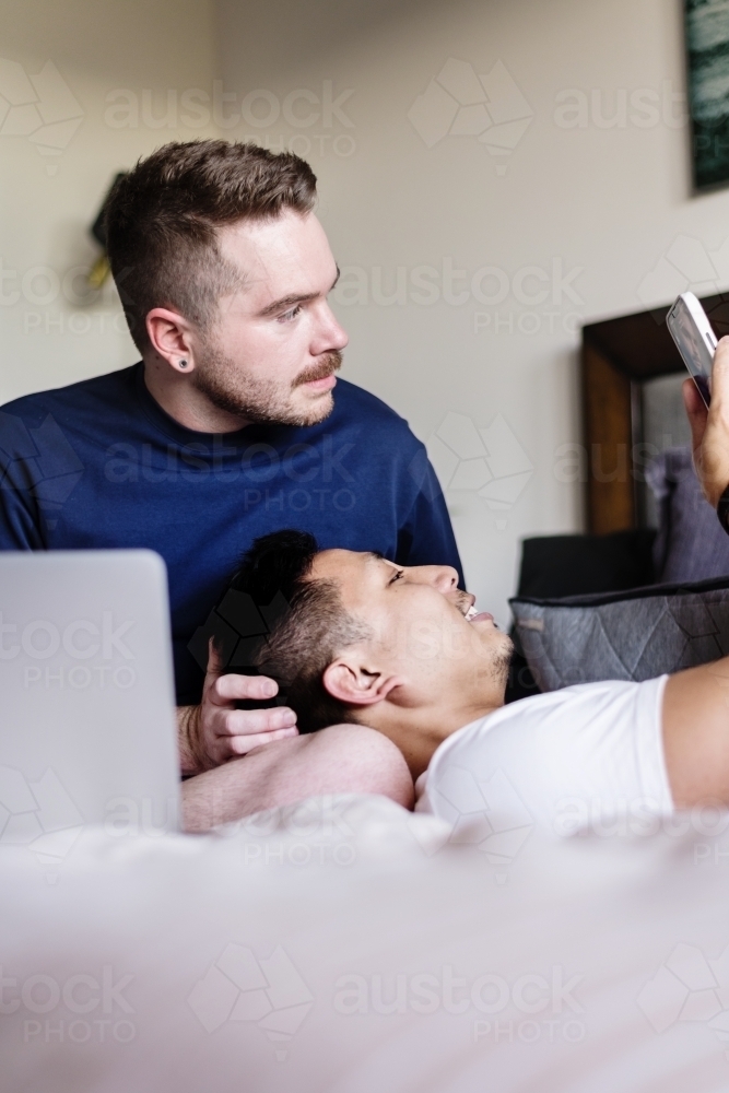 gay couple hanging out at home in the bedroom - Australian Stock Image