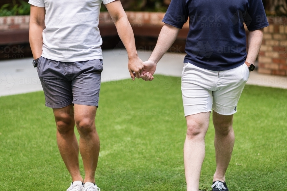 Gay couple holding hands - Australian Stock Image