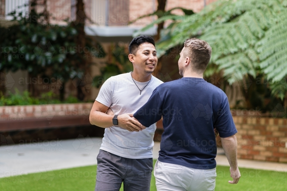 Gay couple walking playfully - Australian Stock Image