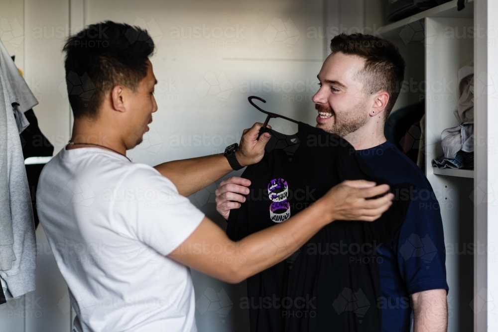 gay man choosing an outfit for his boyfriend - Australian Stock Image