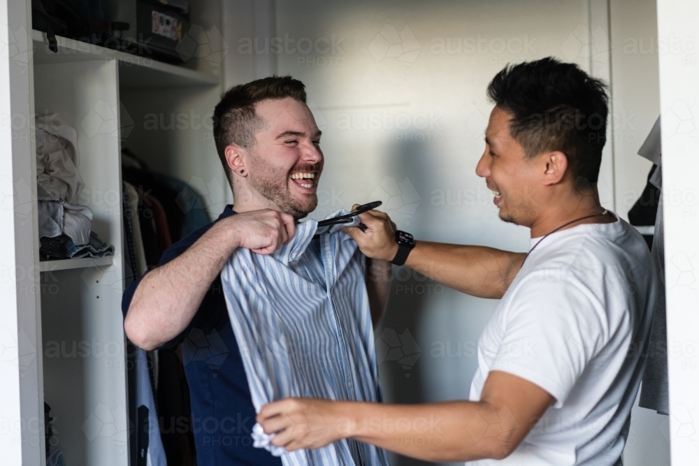 gay man choosing an outfit for his boyfriend - Australian Stock Image