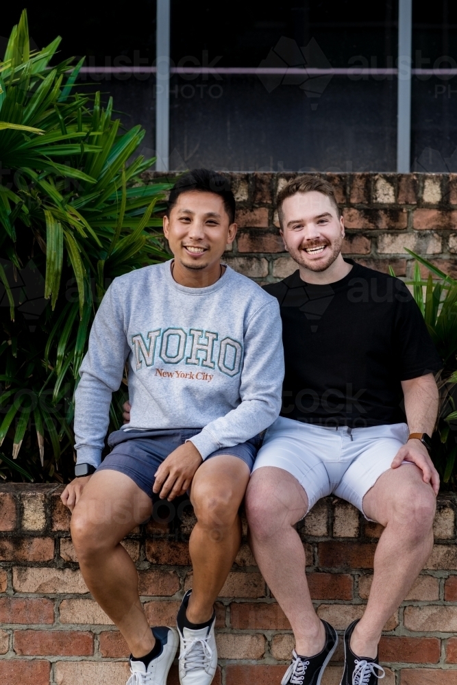 gay men sitting outside, smiling - Australian Stock Image