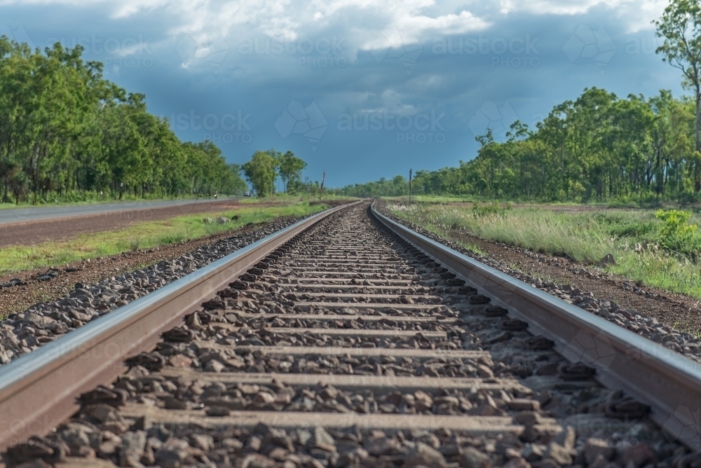 Ghan tracks near Darwin with storm approaching - Australian Stock Image