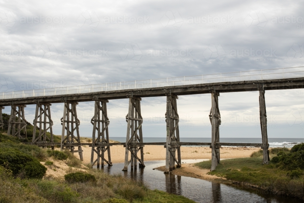 Gipplsand, Kilcunda Bourne Creek Trestle bridge on an overcast day with ocean in background : Austockphoto Gipplsand, Kilcunda Bourne Creek Trestle bridge on an overcast day with ocean in background - Australian Stock Image