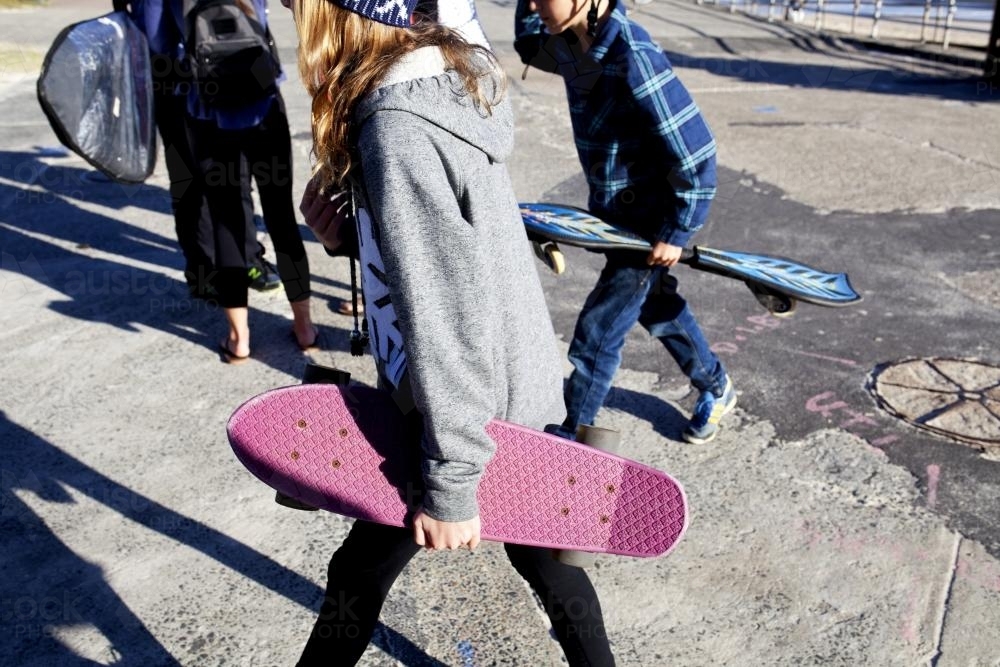 Girl and boy holding their skateboards - Australian Stock Image