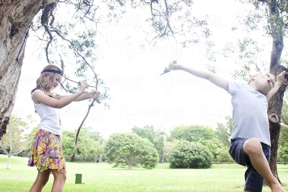 Girl and boy playing dress ups in a park - Australian Stock Image