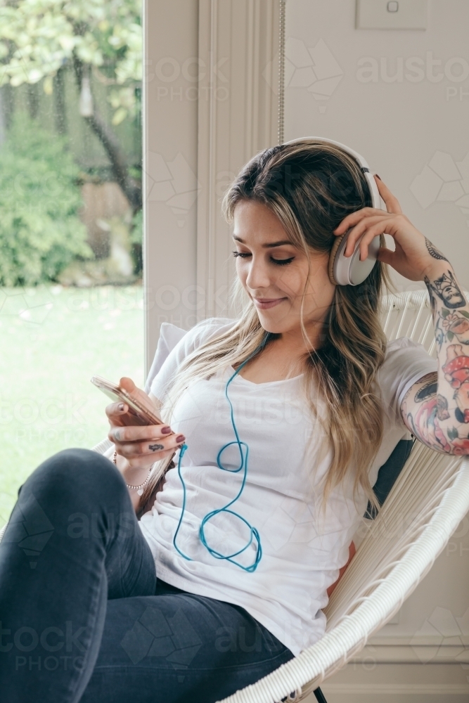 Girl at home relaxing while listening to music - Australian Stock Image