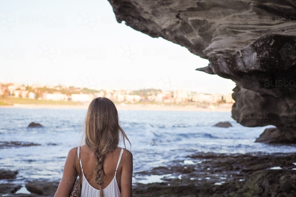 Girl Beside Rocks Looking onto Bondi Beach - Australian Stock Image