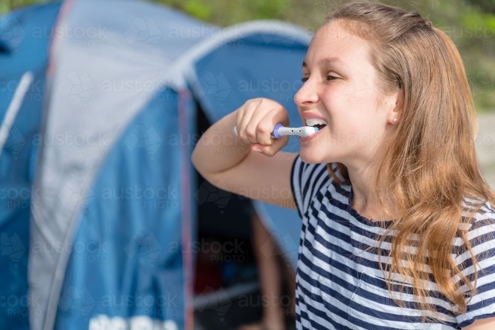 girl brushing her teeth on a camping trip - Australian Stock Image