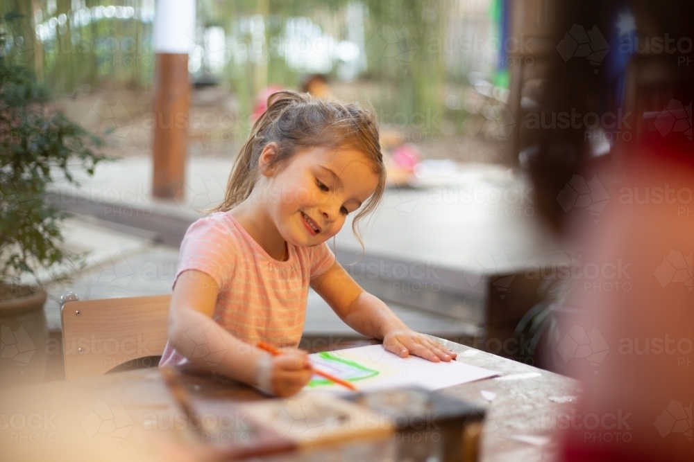 Girl drawing in early education setting - Australian Stock Image