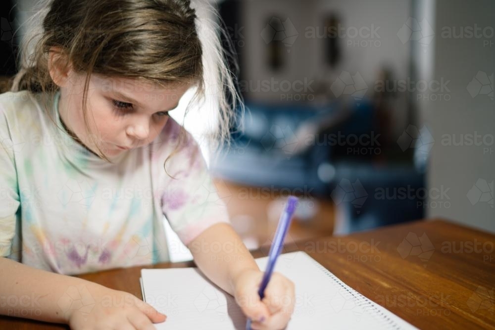 Girl Drawing with a Purple Pen - Australian Stock Image