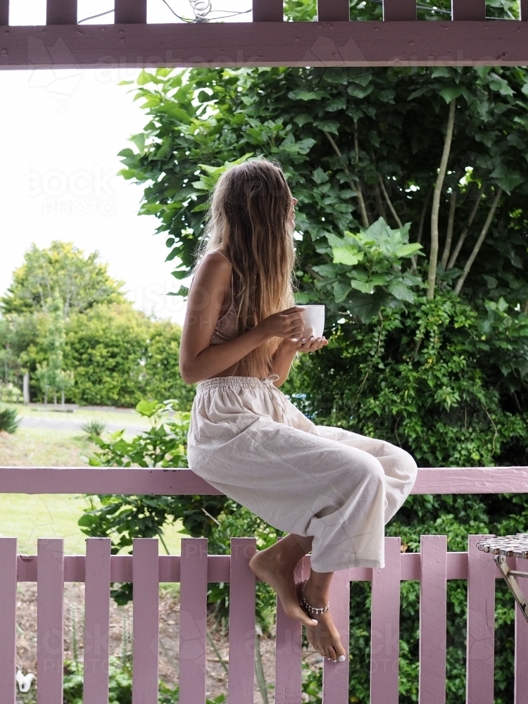 Girl drinking tea on veranda - Australian Stock Image