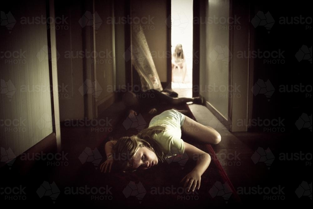 Girl fallen in hallway - creepy - Australian Stock Image