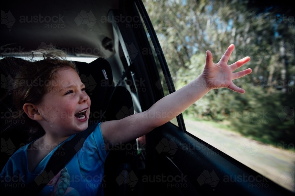 Girl feeling the wind out the car window - Australian Stock Image
