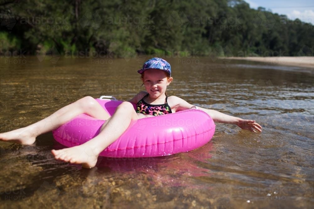 Girl floating on a river in an inflatable ring - Australian Stock Image