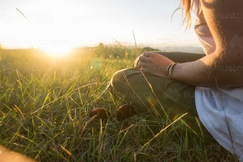 Girl getting warmth from the last light of the day - Australian Stock Image
