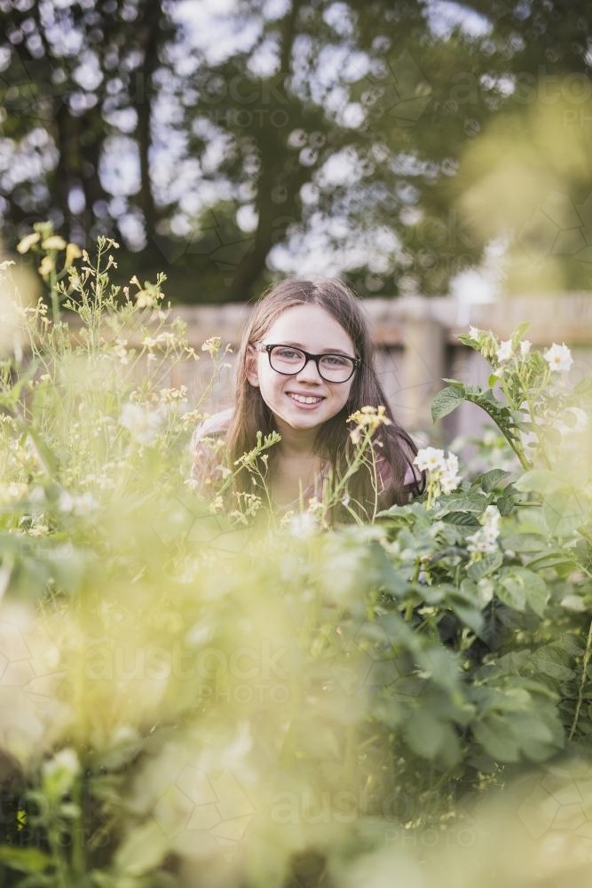 Girl hiding in potato plants - Australian Stock Image