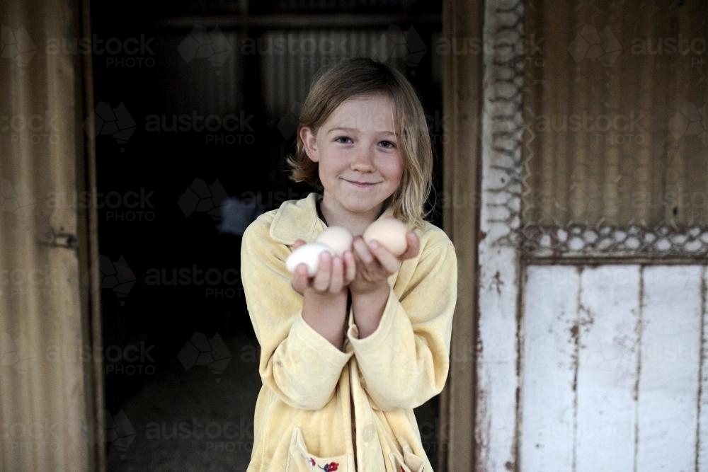 Girl holding free range eggs collected from hen house - Australian Stock Image
