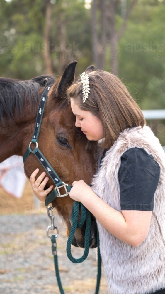 Girl holding her horses head close - Australian Stock Image