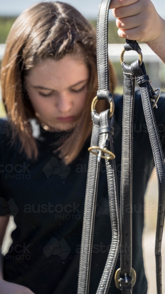Girl holding horse bridle out of focus - Australian Stock Image