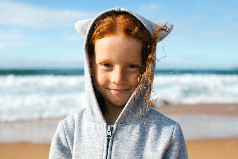 Girl in a hoodie with animal ears at the beach - Australian Stock Image