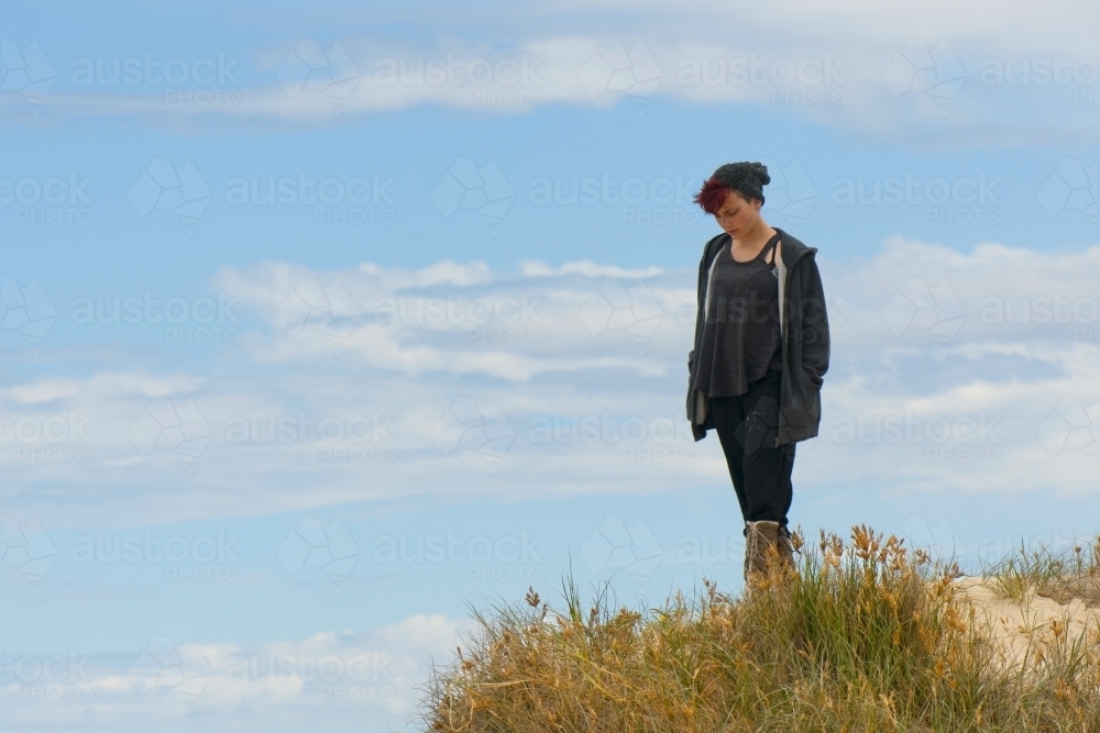 Girl in grey jacket at the beach - Australian Stock Image