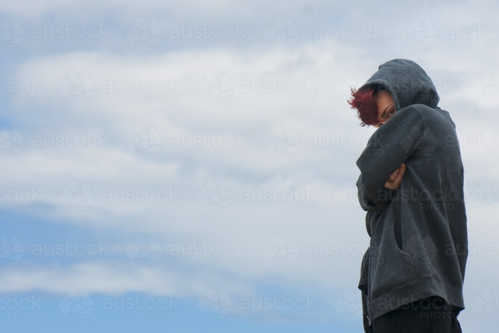 Girl in grey jacket scowling cheekily - Australian Stock Image