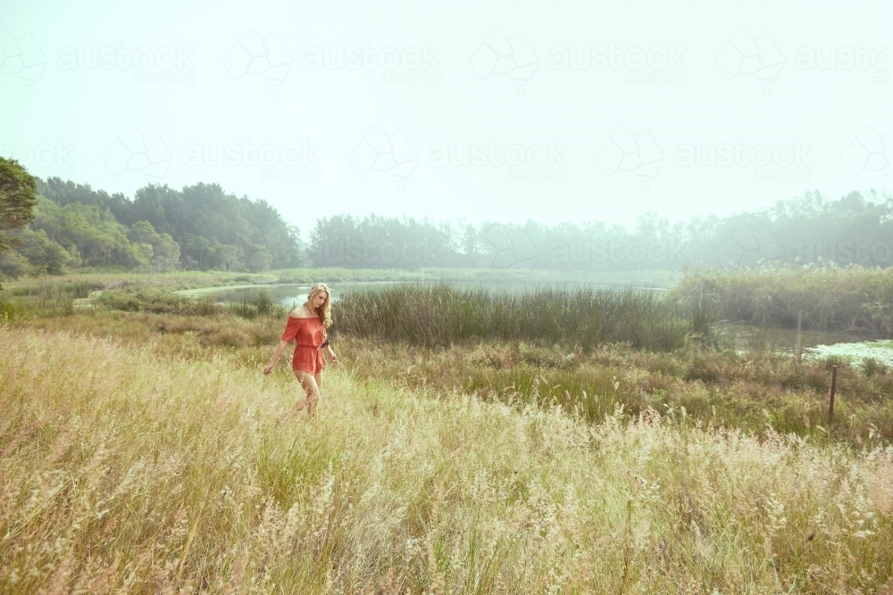 Girl in red walking in nature in a vintage style - Australian Stock Image
