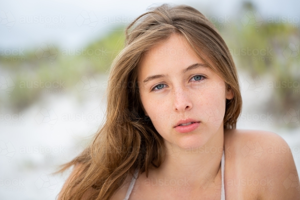 Girl in sand dunes with hair in eyes and sand on face - Australian Stock Image