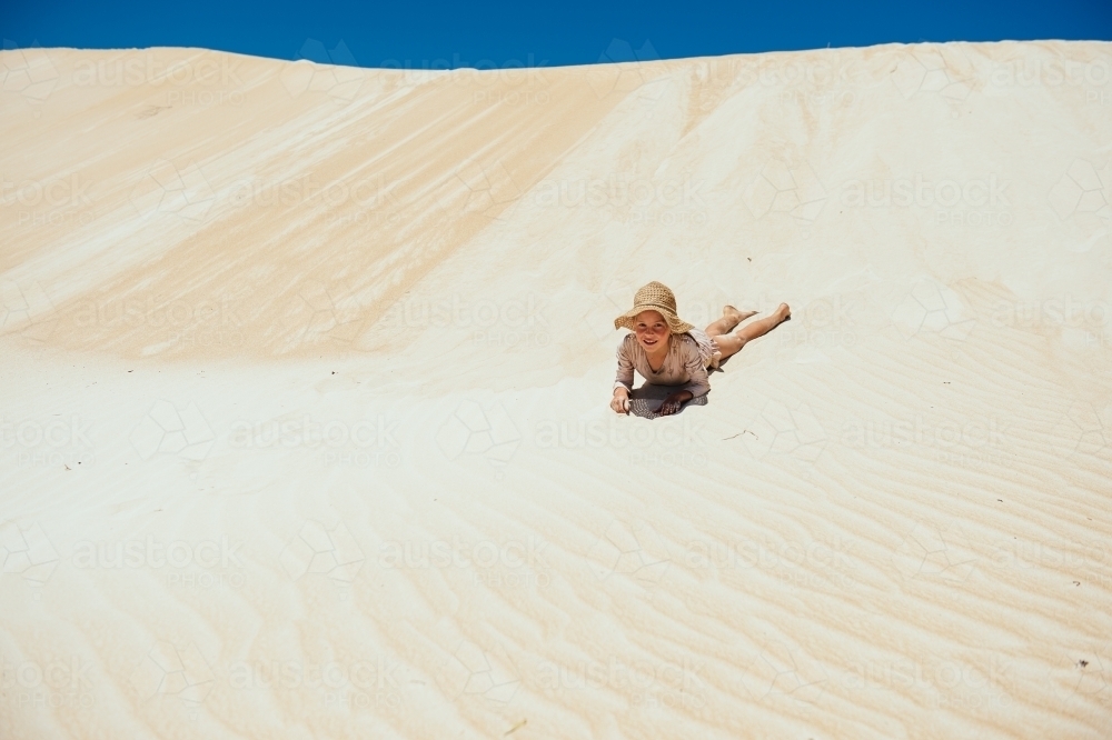 Girl laying in the sand dunes - Australian Stock Image