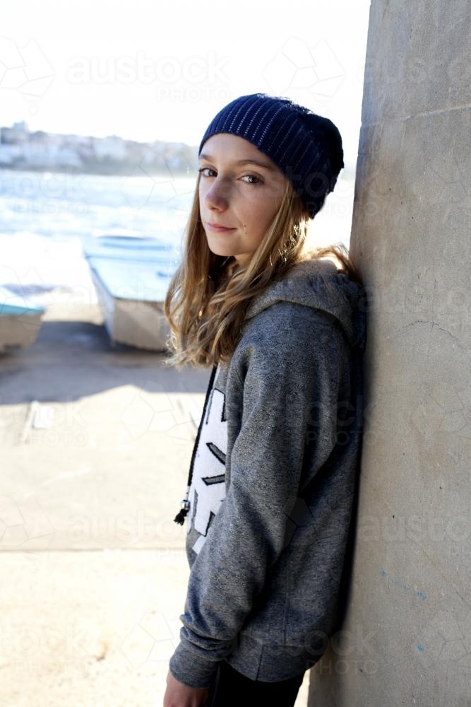 Girl leaning against wall by the seaside - Australian Stock Image