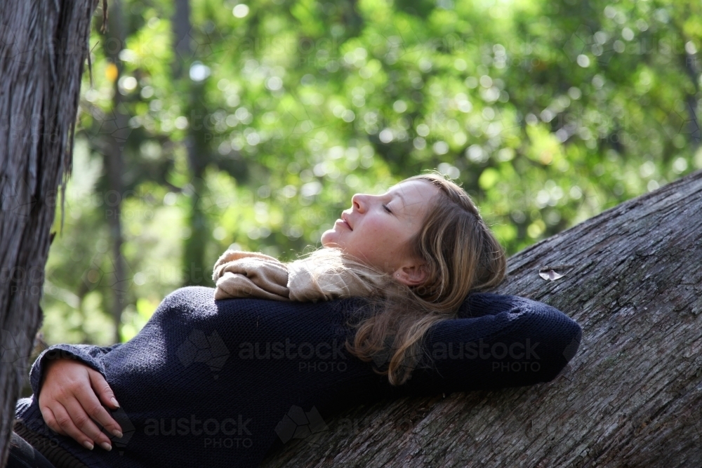 Girl leaning back on tree - Australian Stock Image
