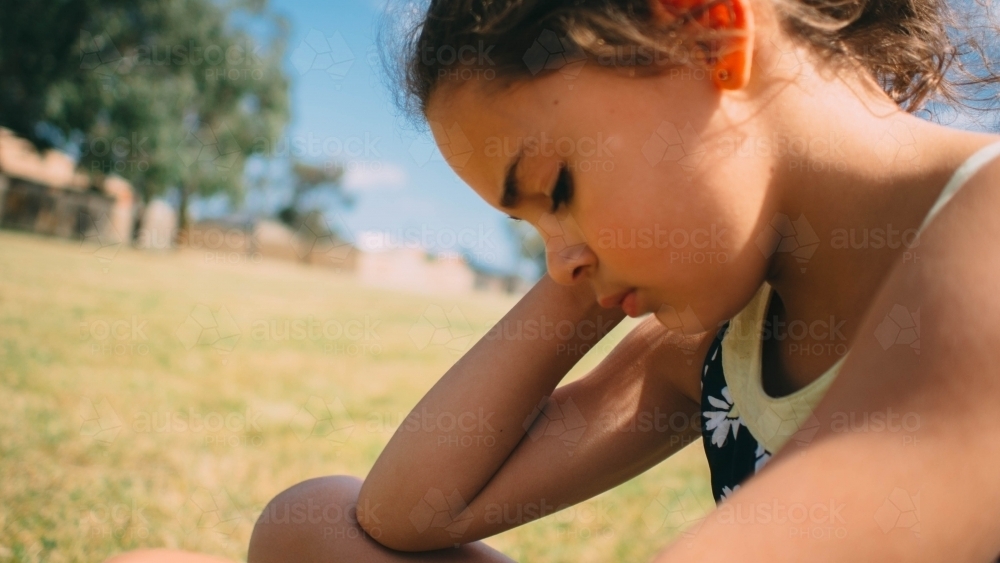 Girl looking sad in the park - Australian Stock Image
