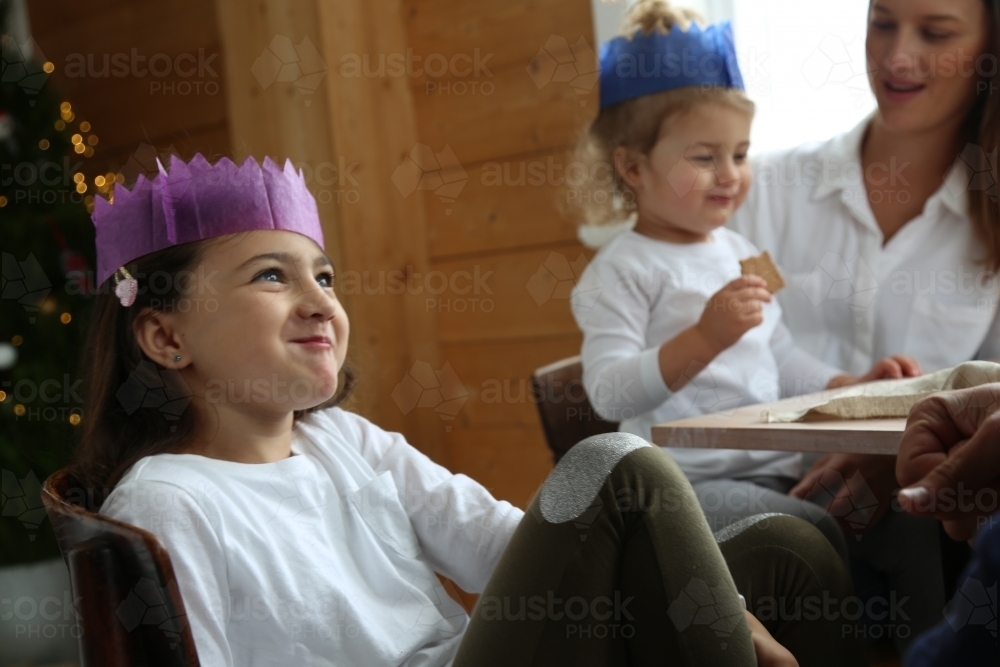 Girl looking up smiling in Christmas hat - Australian Stock Image