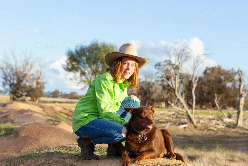 Girl on a farm with red kelpie dog - Australian Stock Image