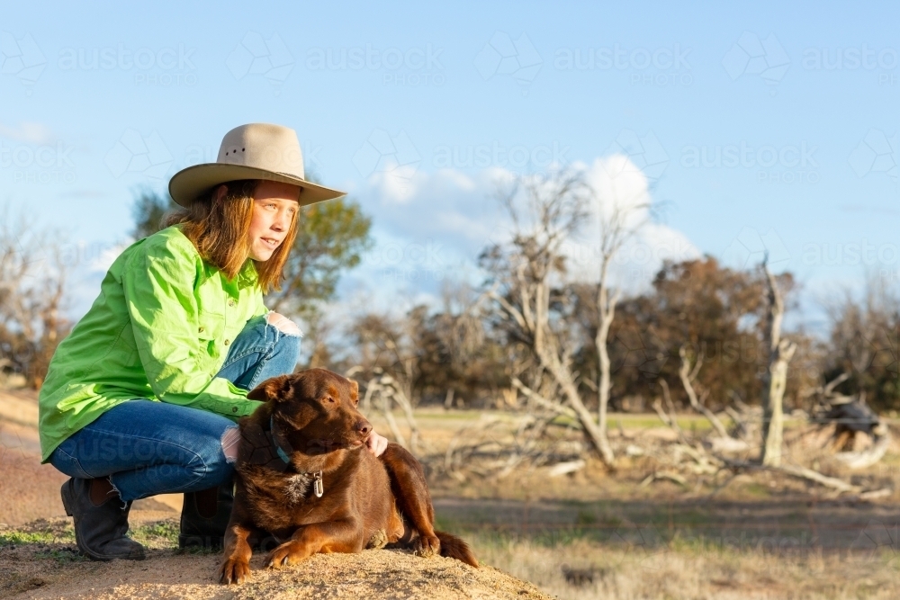 Girl on a farm with red kelpie dog - Australian Stock Image