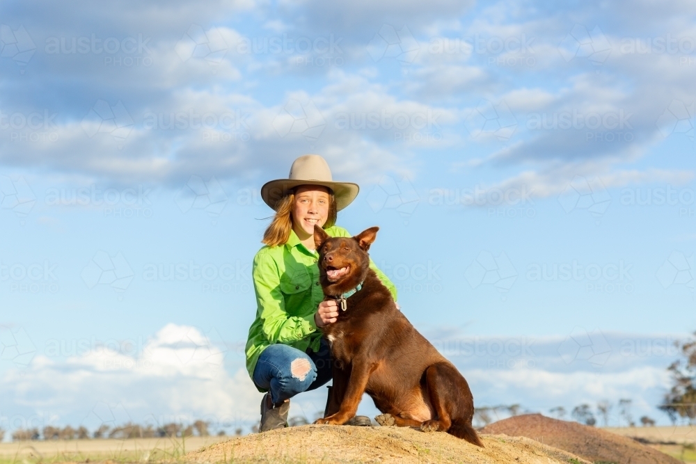 Girl on a farm with red kelpie dog - Australian Stock Image