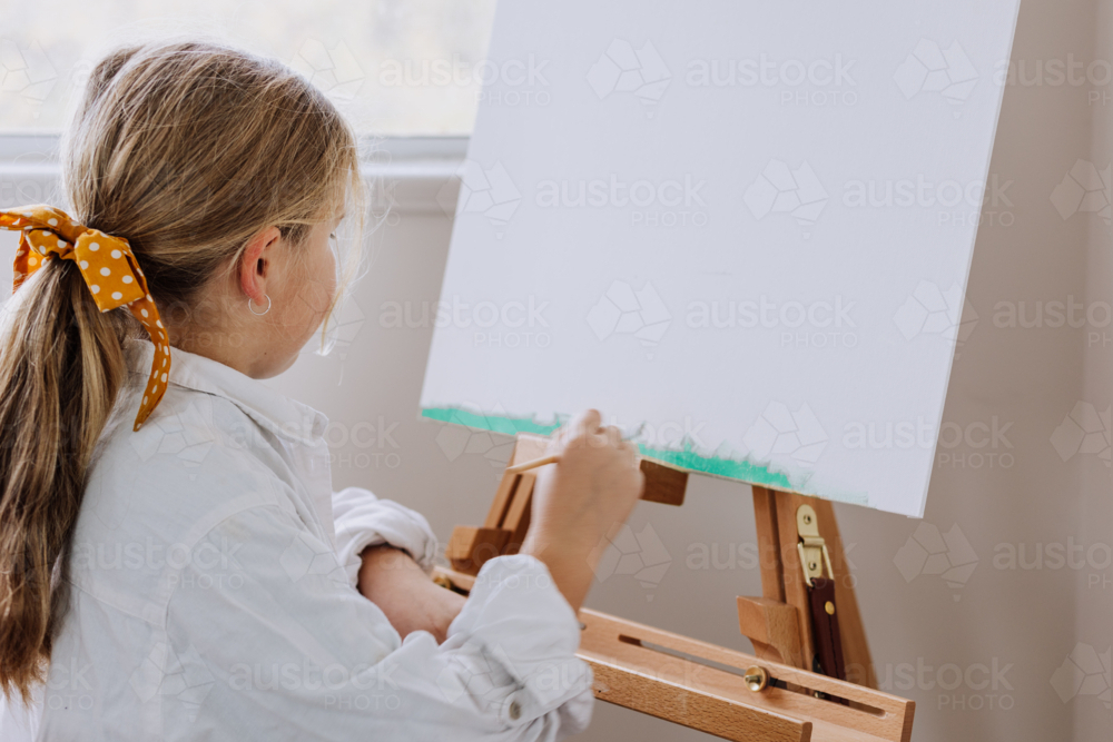 Image of Girl painting on canvas in a home studio - Austockphoto