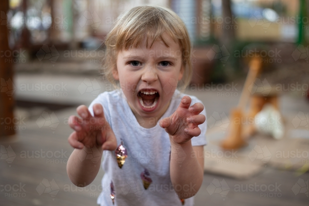 Girl preschooler growling like a fierce tiger - Australian Stock Image